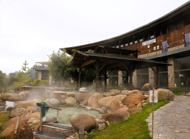 Paseo Termal del Río Miño: Termas de Outariz Zona termal al aire libre con piscinas y edificios de madera