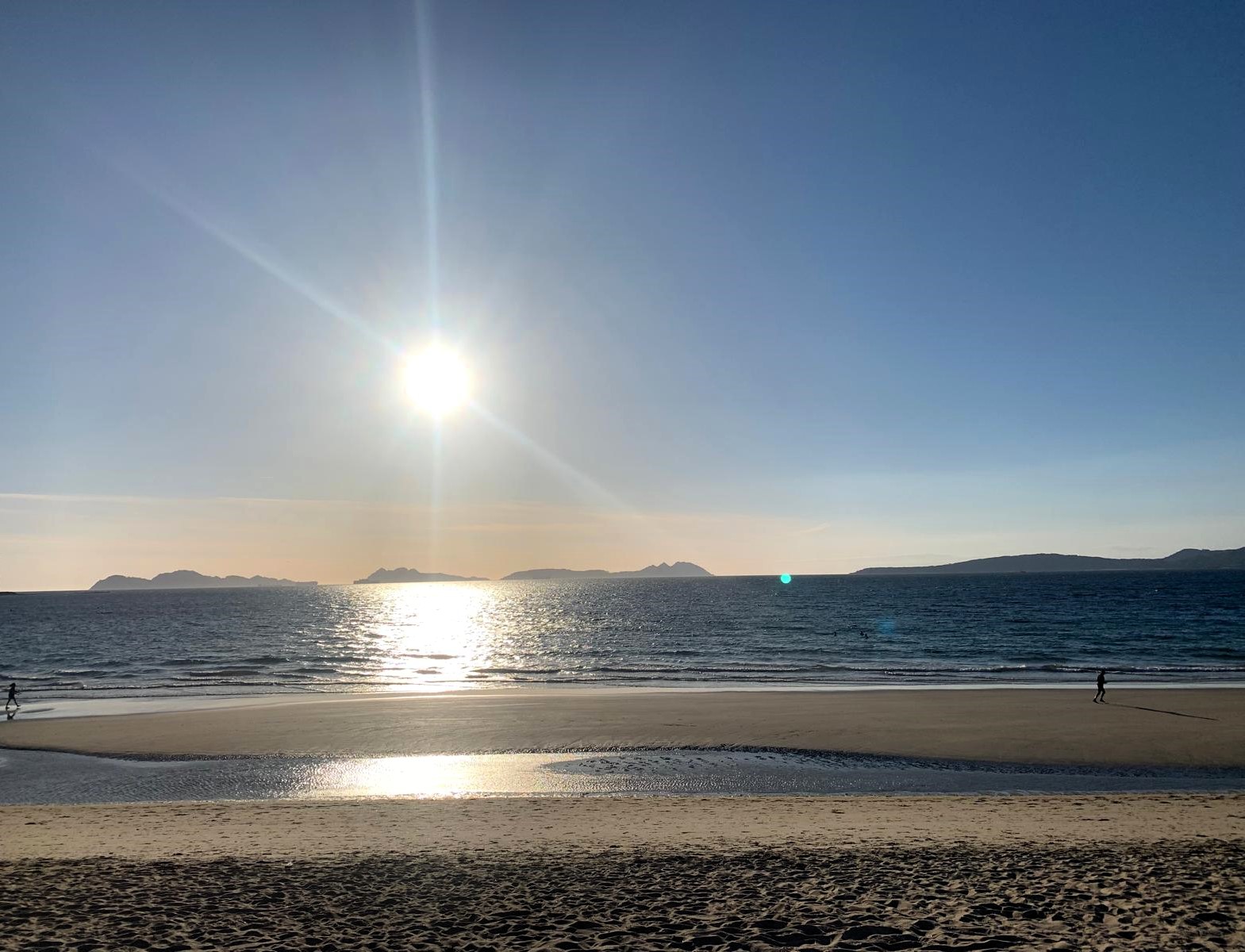 Reflejo del sol sobre el mar en la playa de Samil
